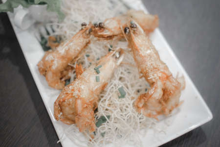 Crispy fried prawn with garlic and pepper in white plateの写真素材