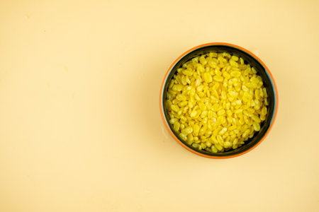 Close up golden color crispy deep fried mung bean in bowl on yellow background. Thai Appetizerの写真素材