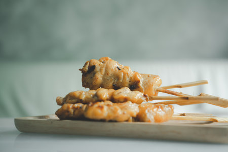 Sticks of grilled skewered turmeric chicken one of the famous street food in Thailandの写真素材