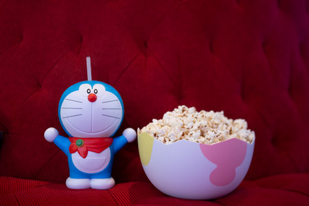 Bangkok, Thailand - December 13, 2020 : Doraemon set of bucket popcorn to promote the movie : Nobita's New Dinosaur from Advertising Major Cineplex Group Plc. on red sofa at cinemaのeditorial素材