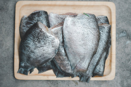 Pile of raw fresh gourami fish on wood trayの写真素材