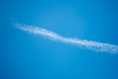 Cloudscape with trail of jet plane on blue sky.の写真素材