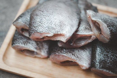Raw gourami fish on a wooden plateの写真素材