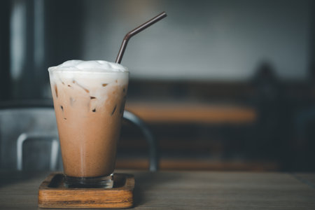 Iced Mocha coffee in a glass decoration with cream on top on a wood tableの写真素材