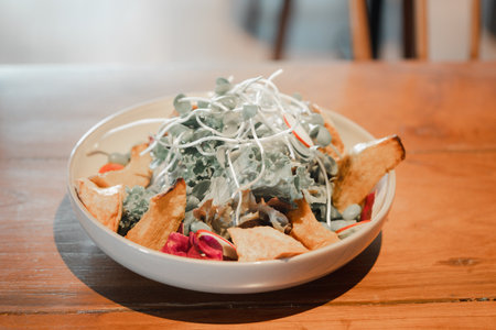 Fried tofu salad mix with vegetable in a white bowl on wood tableの写真素材