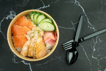 Top view of salmon don, fresh raw salmon, burn salmon and pickled ginger on the Japanese sour rice. Take home or delivery food.の写真素材