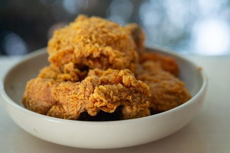 Close up crispy fresh fried chicken on a white round plateの写真素材