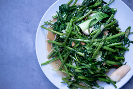 Stir fried morning glory with garlic and fresh peppers.の写真素材