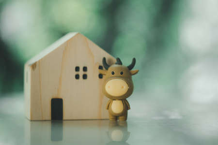 Cute doll ox stand with wood miniature home. Chinese new year. Year of the oxの写真素材