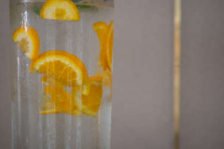 Drink cool water in glass cooler and some sliced orange inside for freshness self service at hotel.の写真素材