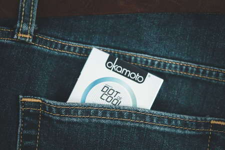 Samut Prakan, Thailand - February 2, 2021 : A box of Okamoto condoms in jean man pocket. Japanese made condom represent.のeditorial素材