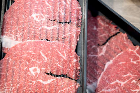 Thin sliced beef for Shabu hot pot meal on black tray