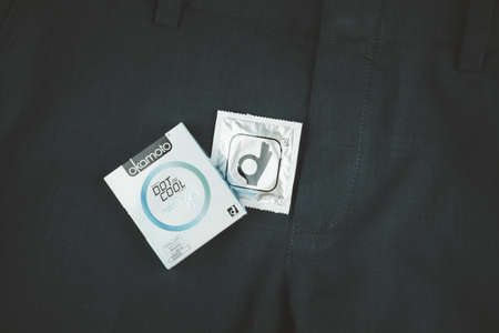 Samut Prakan, Thailand - February 2, 2021 : Box of Okamoto Dot De Cool Condom 52mm on man blue slack...