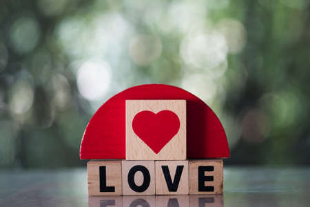 Wooden red hearts cubes place on wooden cubes with word of LOVE. Valentine love seasonの写真素材