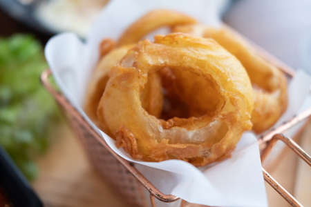 Fried onion rings served in baskets at cafe or restaurants