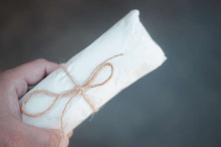 Man hand holding paper packaging wrapped by rope. Concept of packaging eco friendly