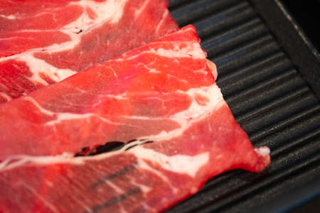 Thin slice beef in black tray for Sukiyaki or shabu shabu.の写真素材