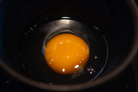 Egg yolks in small black bowl for eating with shabu and sukiyaki