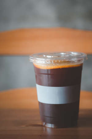Iced orange juice infused with espresso coffee decorating with sliced orange piece in plastic cup on...