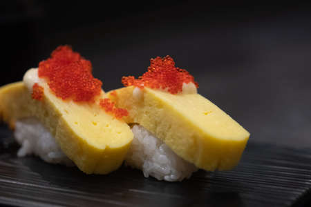 Tamago Sushi served on black tray - japanese food styleの写真素材