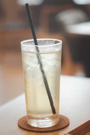 Iced green tea with black straw on wood tableの写真素材