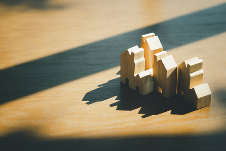 Group of mini wooden home model placed on wooden table with lighting morning and shadow. House ownership or real estate business conceptの写真素材