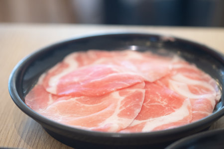 Fresh pork thinly sliced on black dish for japanese hot potの写真素材