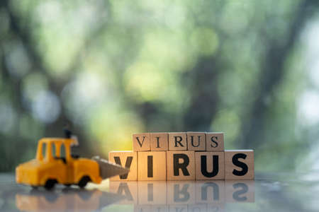 Toy drill car kill to VIRUS text in wooden blocks. Beat virus concept. People fight virus concept.の写真素材