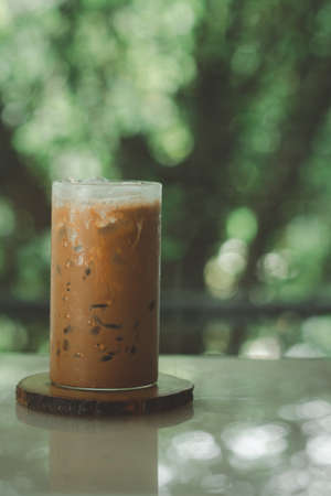 Iced mocha coffee in front of a nature background on wooden saucer.の写真素材
