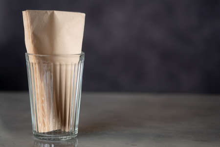 Napkin brown tissue paper in glass cup for Customer on table at restaurants. Recycled paper good for environmentの写真素材