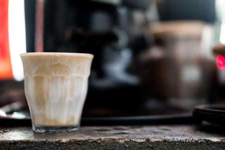 Hot coffee in dirty coffee style with white creamy milk and espresso in transparent glass in coffee shop cafeの写真素材