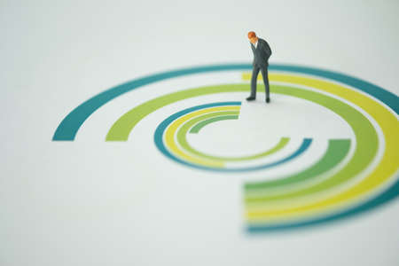 Miniature businessman standing on the circle chart paper and stance with thinking. Business conceptualの写真素材