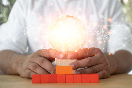 Man holding light bulb with network connection virtual interface, innovative technology in science and communication concept. Concept new idea with innovation and creativityの写真素材