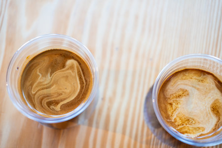 Two cup of dirty coffee on wooden table background. Top view