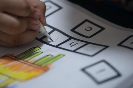 Little boy write to paper with pencil on desk. The concept of practice writingの写真素材