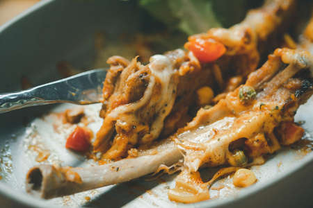 Selective focus bone of BBQ ribs after finished eating on dirty dish in restaurant.