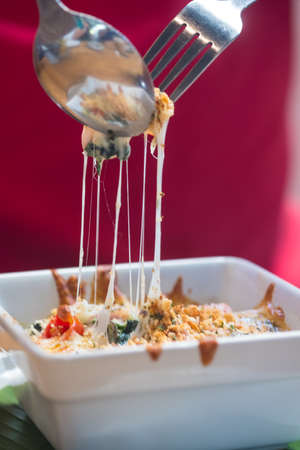 Eating baked spinach with cheese. Selective focus