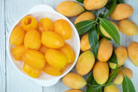 Mayongchid with seeds removed ready to eat on white dish and mayongchid with green leaf.の写真素材