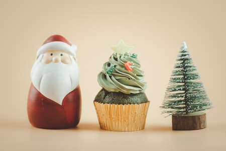 Christmas tree cupcake with santa claus doll and Christmas tree on a yellow background. Holiday Backgroundの写真素材