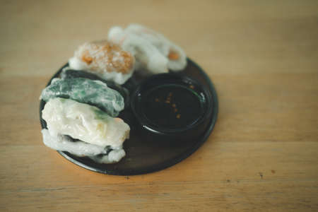 Mix of various steamed dumpling stuffed such as garlic chives, taro and bamboo shoot with sweet sauce in dish, ready to eatの写真素材