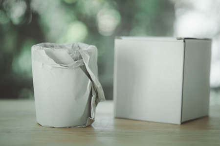Glass water drink wrapped in craft paper on wood table.