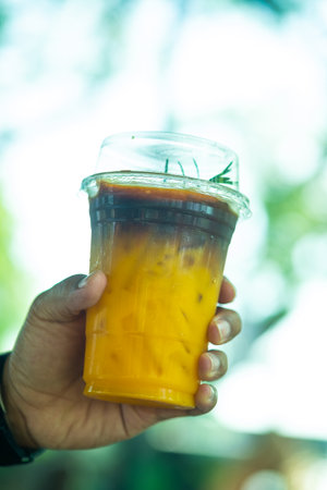 Orange juice mix with espresso and ice. Fusion coffee in man handの写真素材