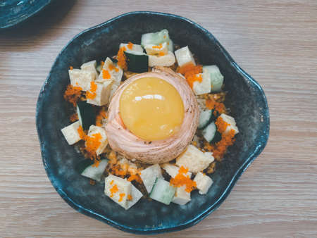 Top view of salmon don, burn sashimi, salmon roe and raw egg on top on wood table