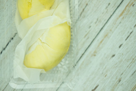 Close up Durian fruit with sharp bark flesh in the sweet yellow color in clear plastic boxの写真素材