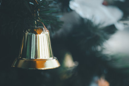 Close up of Christmas gold colour bell hanging on Christmas tree, ornamentsの写真素材