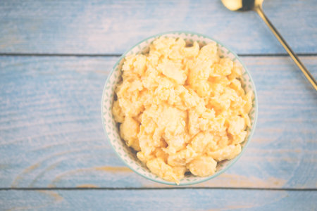 Scrambled eggs in bowl on wood background. Top viewの写真素材