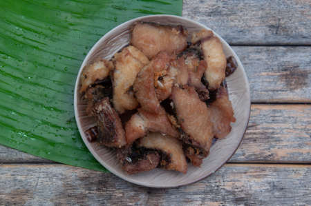 Deep fried fish on dish placed on wood table