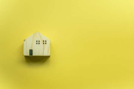 Wood blocks on a yellow background. Little wooden house.の写真素材
