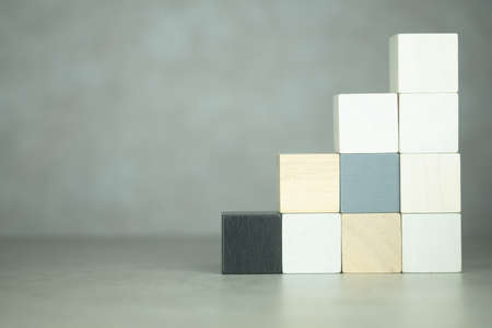 Wooden block stacking as step stair on wooden table backgroundの写真素材