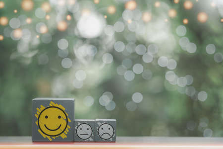 Close up of icon happy, neutral and negative faces on wood cubes. Service rating, satisfaction concept.の写真素材